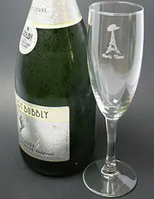 Champagne bottle and flute on table.